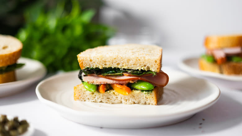 ham and vegetable sandwich on white plate