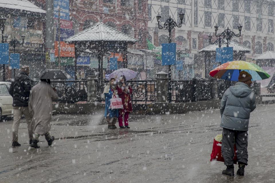 Kashmiri women wait for public transport as it snows in Srinagar, Indian controlled Kashmir, Saturday, Jan. 28, 2017. Authorities in Indian-controlled Kashmir have issued avalanche warnings for many parts of the region, as the heavy snowfall has cut off roads, disrupted power and communication lines, and forced the evacuation of hundreds of residents. (AP Photo/Dar Yasin)