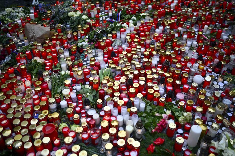 Candles are placed outside the headquarters of Charles University for victims of mass shooting in Prague, Czech Republic, Friday, Dec. 22, 2023. A lone gunman opened fire at a university on Thursday, killing more than a dozen people and injuring scores of people. (AP Photo/Denes Erdos)