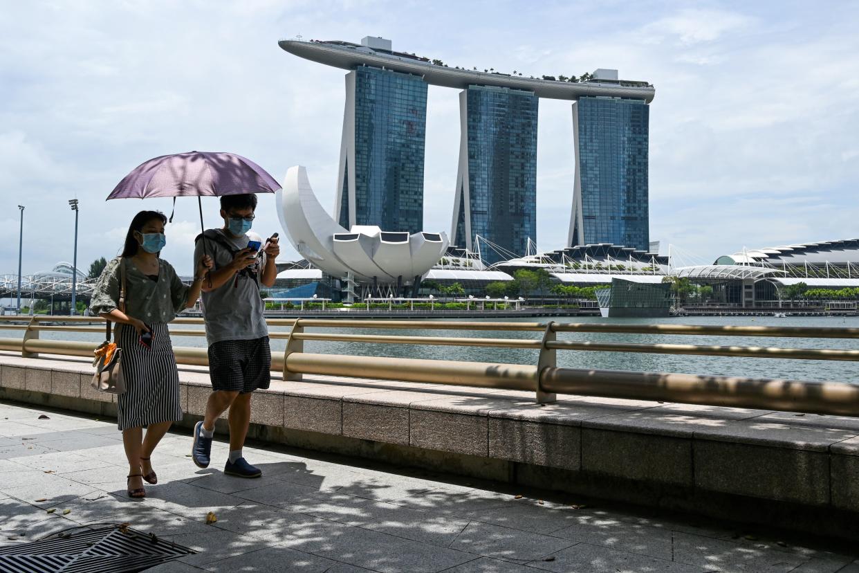 A couple wearing face mask walk along the Marina Bay in Singapore on August 27, 2020. (Photo by Roslan RAHMAN / AFP) (Photo by ROSLAN RAHMAN/AFP via Getty Images)