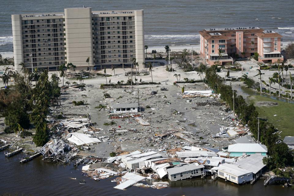 This aerial photo shows damaged homes and debris in the aftermath of Hurricane Ian, Thursday, Sept. 29, 2022, in Fort Myers, Fla. (AP Photo/Wilfredo Lee)