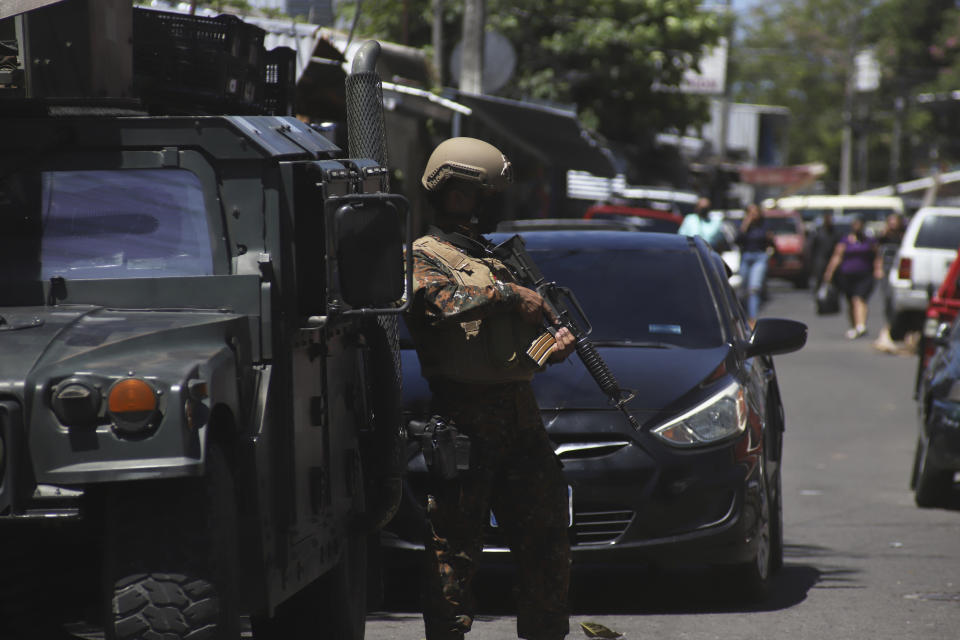 Soldiers man a checkpoint at the entrance to the Las Palmas Community, a neighborhood that is supposed to be under the control of Barrio 18 Gang in San Salvador, El Salvador, Sunday, March 27, 2022. El Salvador's congress has granted President Nayib Bukele request to declare a state of emergency, amid a wave of gang-related killings over the weekend. (AP Photo/Salvador Melendez)