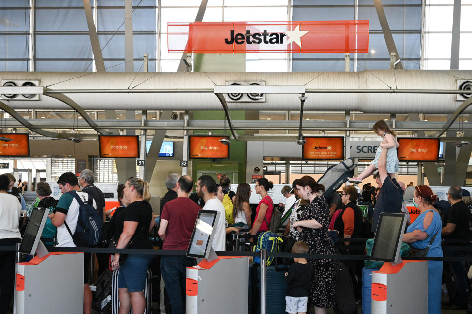 Travelers wait in line at a Jetstar Airways counter.