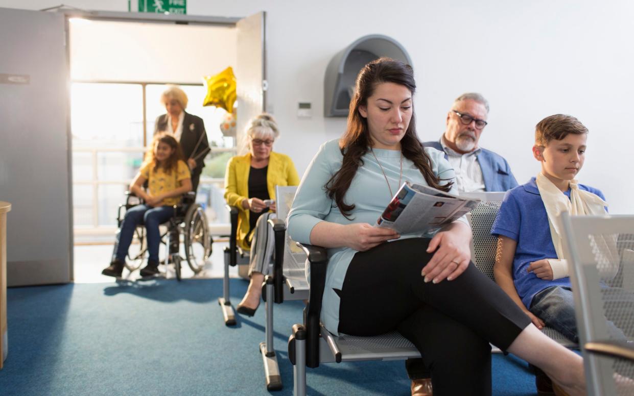 A posed stock image of people waiting to see a doctor