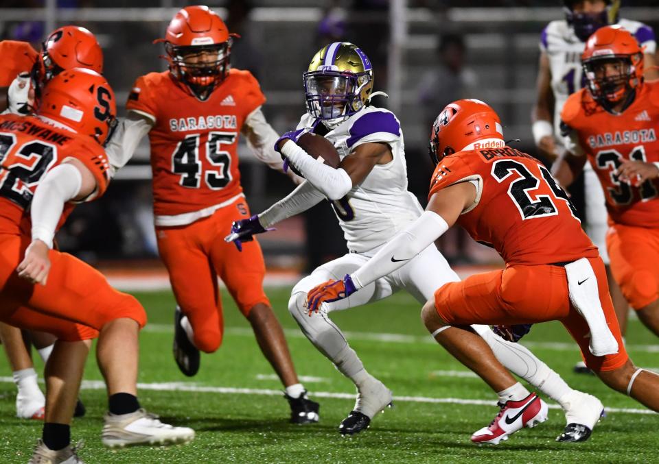 Booker High wide receiver Omarion Patterson (#0) looks for an opening against Sarasota High defenders Friday, Sept. 8, 2023 at Sarasota High.