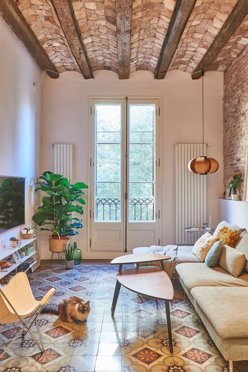 Brick lined walls and ceiling in light filled apartment living room.