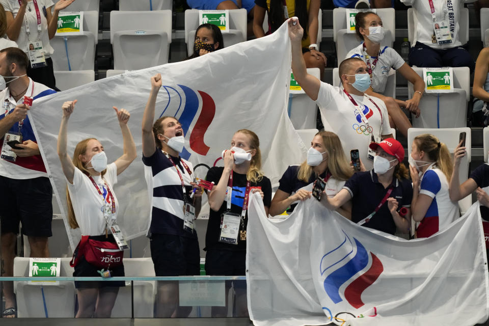 Supporters of Russian Olympic Committee team cheer Svetlana Kolesnichenko and Svetlana Romashina of Russian Olympic Committee after their competition in the Free Routine Final at the 2020 Summer Olympics, Wednesday, Aug. 4, 2021, in Tokyo, Japan. (AP Photo/Dmitri Lovetsky)