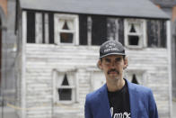 Artist Ryan Mendoza poses for photographers in front of the house of U.S. civil rights campaigner Rosa Parks, which he rebuilt for public display, in Naples, Italy, Tuesday, Sept. 15, 2020. The rundown, paint-chipped Detroit house where Parks took refuge after her famous bus boycott is on display in a setting that couldn't be more incongruous: the imposing central courtyard of the 18th century Royal Palace. (AP Photo/Gregorio Borgia)