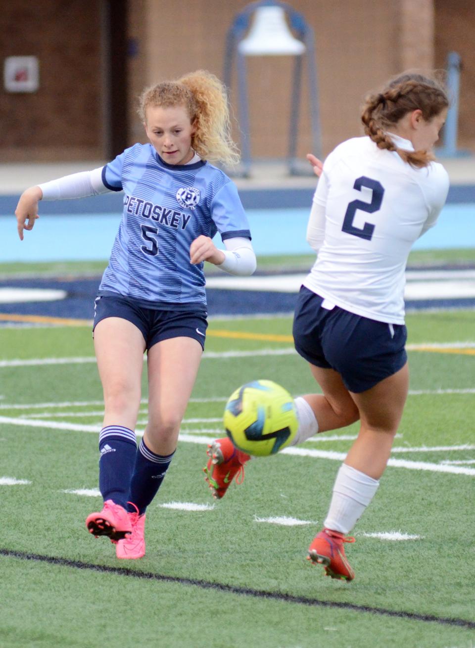 Petoskey's Hope Wegmann (5) clears a ball in Petoskey's end with a shot past Gaylord's Emma Ross Thursday.