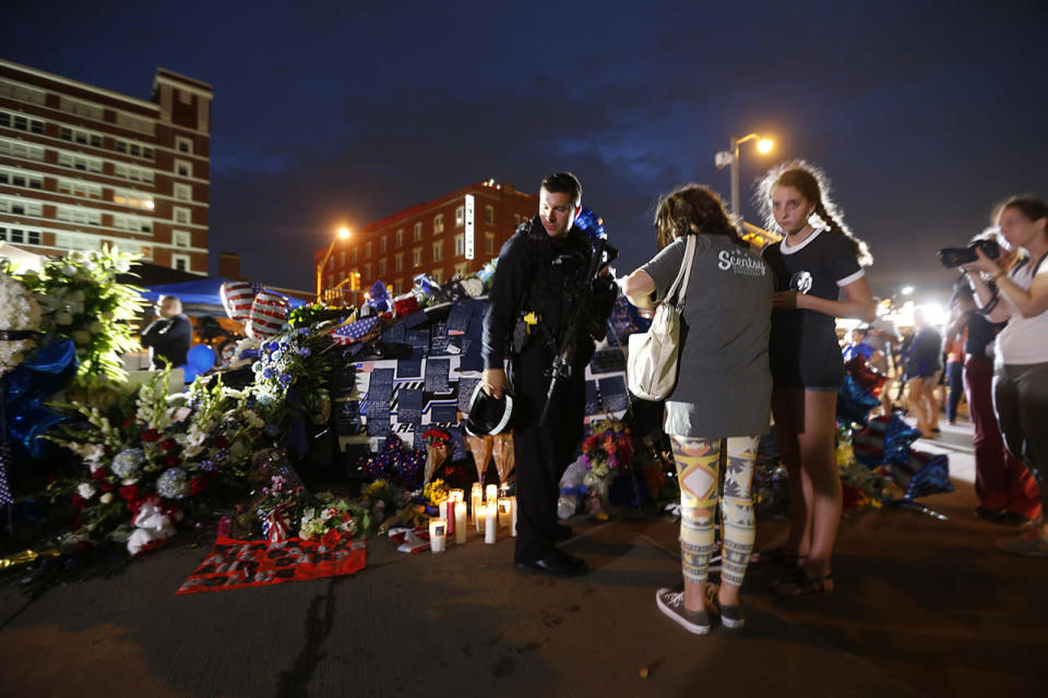 Dallas police officer M. Bono, no first name given, visits a makeshift memorial in honor of the slain Dallas police officers