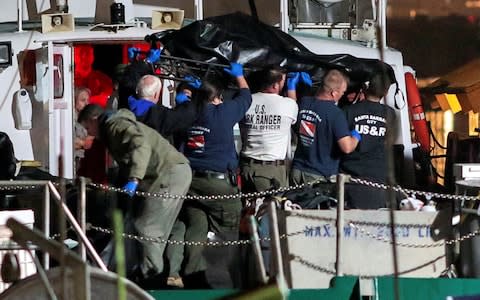 Rescue personnel return to shore with the victims - Credit: Reuters