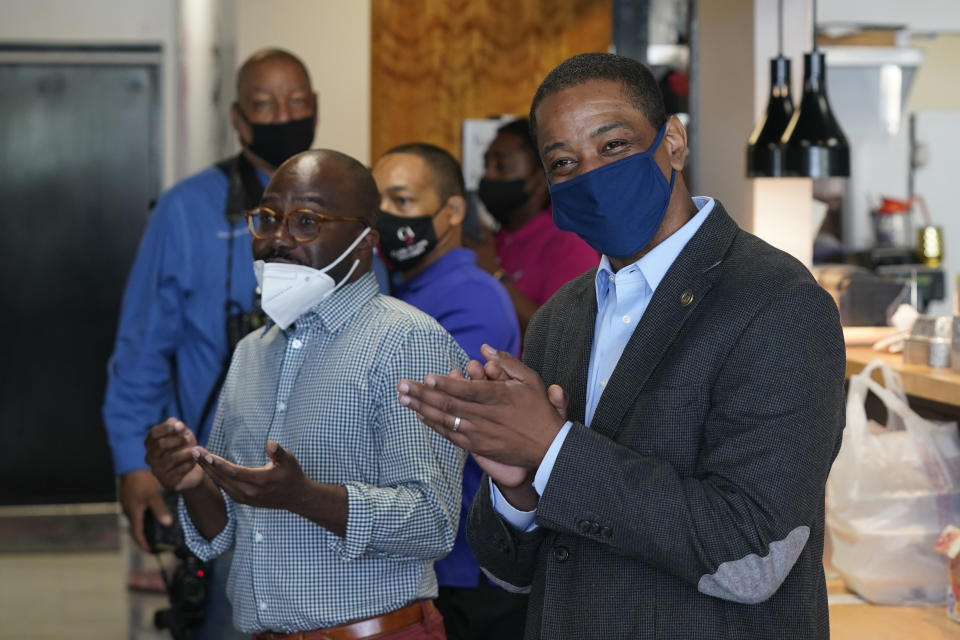 Virginia Democratic gubernatorial candidate Lt. Gov. Justin Fairfax, right, greets supporters at Pink Fish restaurant in Hampton, Va., Thursday, April 8, 2021. Fairfax has long had lofty political ambitions, and despite facing two unresolved allegations of sexual assault he’s pressing forward with a bid for governor. (AP Photo/Steve Helber)