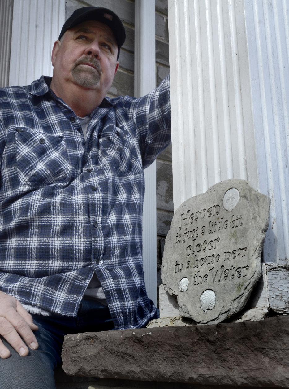 Paul Garrett sits in front of his home in Jersey Shore, Pa. on Sunday March 23, 2014. With an expected increase in flood insurance rates, he says, "It's going to turn the towns that are on the river into ghost towns. Because nobody's going to want to pay that. Nobody's going to want to live here. Property values are going to plummet." (AP Photo/Ralph Wilson)