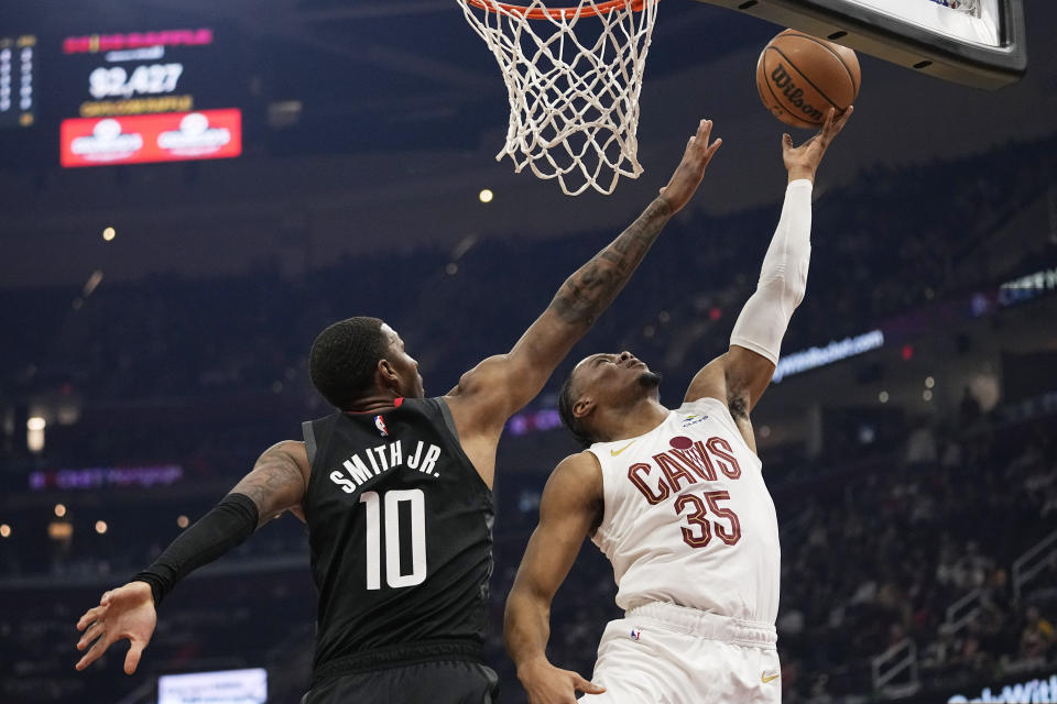 Cleveland Cavaliers forward Isaac Okoro (35) shoots as Houston Rockets forward Jabari Smith Jr. (10) defends in the first half of an NBA basketball game, Monday, Dec. 18, 2023, in Cleveland. (AP Photo/Sue Ogrocki)