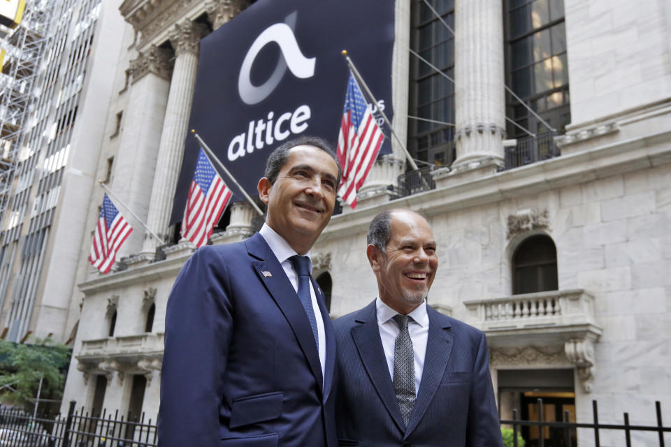 Altice founder Patrick Drahi, left, and co-founder Armando Pereira pose for photos outside the New York Stock Exchange, before the company's IPO, Thursday, June 22, 2017. (AP Photo/Richard Drew)
