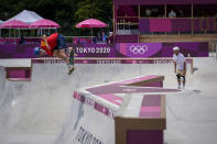 Dallas Oberholzer, 46, right, from South Africa, watches as other skaters practice in a men's Park Skateboarding training session at the 2020 Summer Olympics, Saturday, July 31, 2021, in Tokyo, Japan. The age-range of competitors in skateboarding's Olympic debut at the Tokyo Games is remarkably broad and 46-year-old Dallas Oberholzer will go wheel-to-wheel with skaters less than half his age. (AP Photo/Ben Curtis)