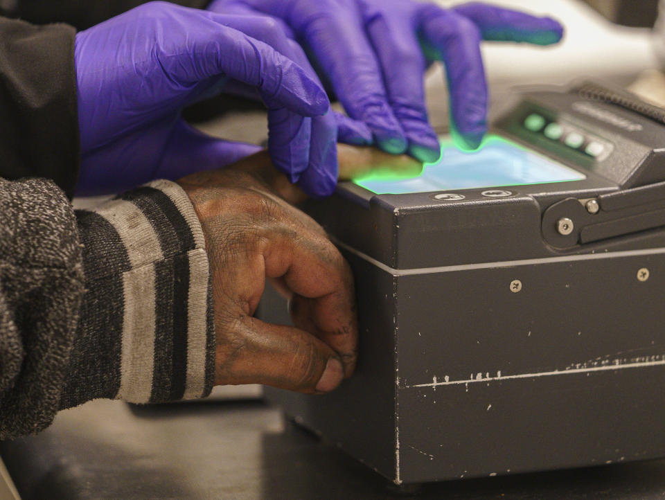 An immigrant considered a threat to public safety and national security has his fingerprints scanned as he is processed for deportation by U.S. Immigration and Customs Enforcement agents at the ICE Metropolitan Detention Center in Los Angeles, after an early morning raid, Monday, June 6, 2022. This weekend, the Biden administration said it would suspend an order prioritizing the arrest and deportation of immigrants considered a threat to public safety and national security in order to comply with a ruling earlier in June 2022, from a Texas judge. Many otherwise law-abiding immigrants living here illegally will now be afraid to leave their homes out of concern they'll be detained. (AP Photo/Damian Dovarganes)