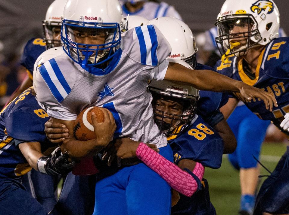 Richview's Ja'Wuan Poe (1) powers forward as Northeast's Tazamire Johnson (88) tries to bring him down during the Clarksville-Montgomery County School System's middle school football championship at Fortera Stadium in Clarksville, Tenn., Tuesday, Oct. 3, 2023.