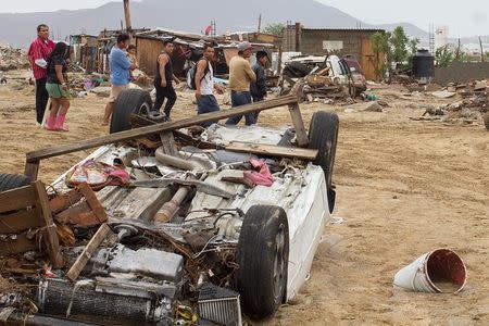 Residents walk past damaged vehicles in the aftermath of Tropical Storm Lidia in Los Cabos, Mexico, September 1, 2017. REUTERS/Fernando Castillo