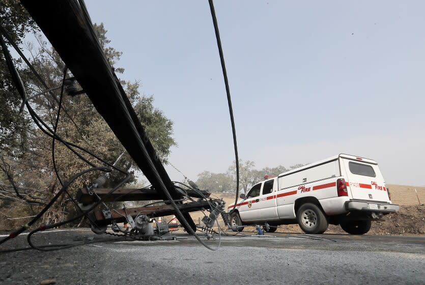 GEYSERVILLE, CALIF. - OCT. 25, 2019. A Calfire vehicle dives past a downed power pole in the Alexander Valley on Friday, Oct. 25, 2019. The Kincade fire has charred about 22,000 acres near Geyserville since it started two days ago. (Luis Sinco/Los Angeles Times)