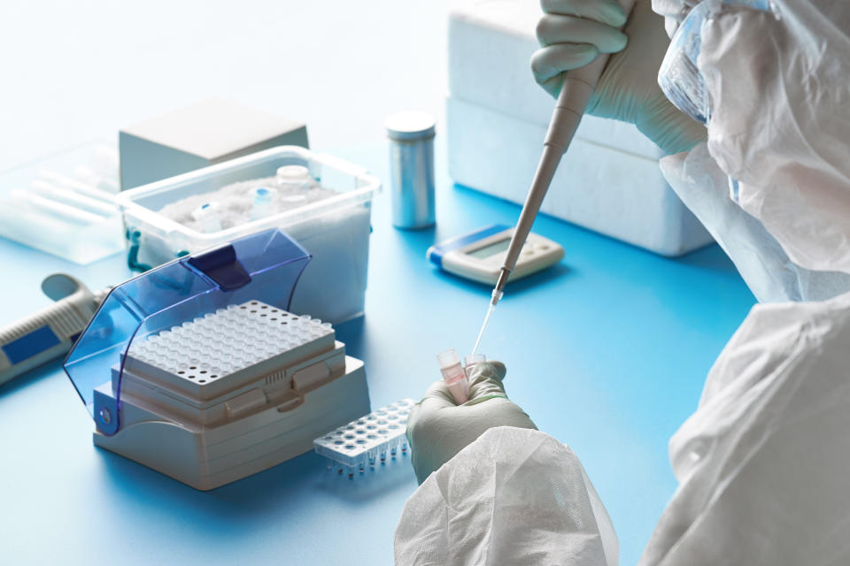 Epidemiologist in protective suit, mask and glasses works with patient swabs to detect specific region of 2019-nCoV virus causing Covid-19 viral pneumonia. SARS-COV-2 pcr diagnostics kit concept.