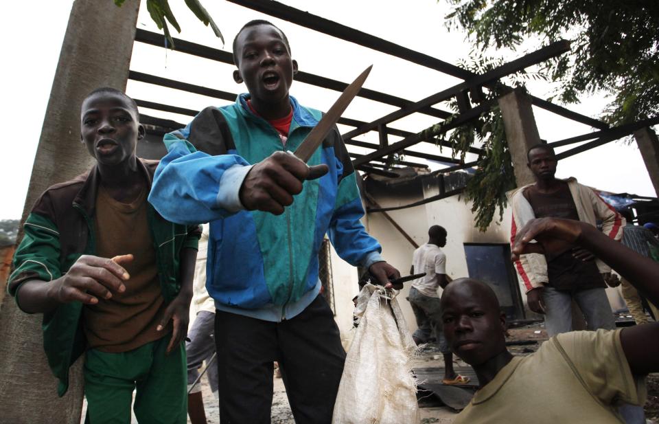 A youth carrying a knife is seen with others during a mosque looting in Bangui December 10, 2013. The French army said it has restored some stability in the capital of Central African Republic after battling gunmen on Monday in an operation to disarm rival Muslim and Christian fighters responsible for killing hundreds since last week. REUTERS/Emmanuel Braun (CENTRAL AFRICAN REPUBLIC - Tags: POLITICS CIVIL UNREST)