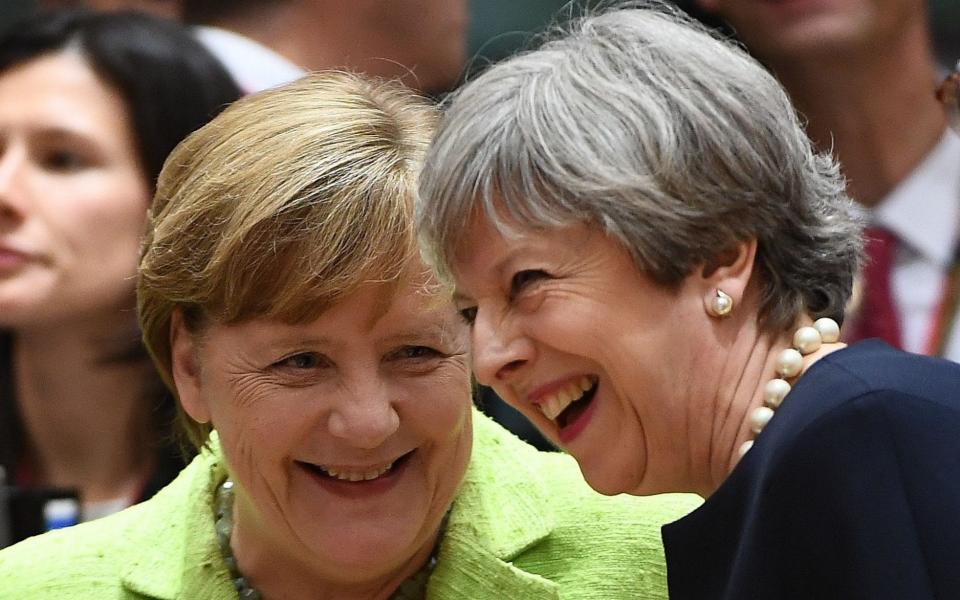 Theresa May with Angela Merkel - AFP