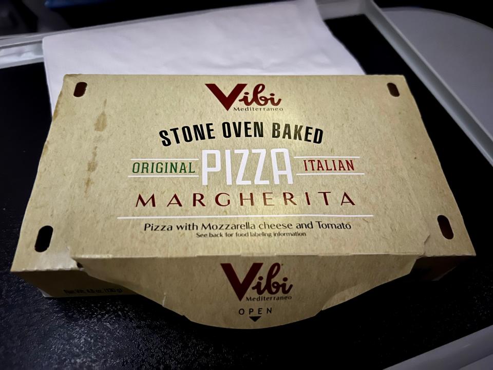 The stone oven baked margherita pizza in its beige box.