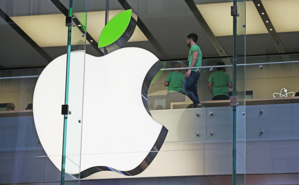 Employees wear green shirts near Apple's familiar logo displayed with a green leaf at the Apple Store timed to coincide with Tuesday's annual celebration of Earth Day in Sydney, Tuesday, April 22, 2014. Apple is offering free recycling of all its used products and vowing to power all of its stores, offices and data centers with renewable energy to reduce the pollution caused by its devices and online services. (AP Photo/Rick Rycroft)