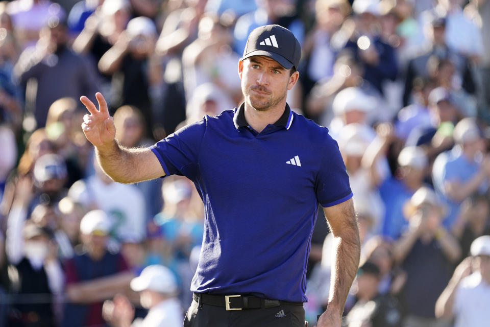 Nick Taylor acknowledges the crowd on the 18th hole during the final round of the Phoenix Open golf tournament, Sunday, Feb. 12, 2023, in Scottsdale, Ariz. (AP Photo/Darryl Webb)