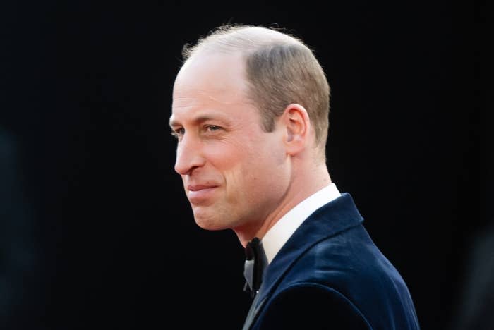 Man in a dark formal suit with a bow tie at an event