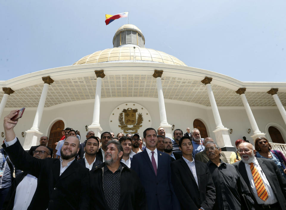 Venezuelan opposition leader Juan Guaido, center right, who has declared himself interim president, poses for a photo with members of a coalition of opposition parties, and other civic groups after their meeting in Caracas, Venezuela, Monday, March 18, 2019. After Guaido declared himself interim president in late Feb., Venezuelan President Nicolas Maduro has remained in power despite heavy pressure from the United States and other countries arrayed against him, managing to retain the loyalty of most of his military leaders. (AP Photo/Natacha Pisarenko)