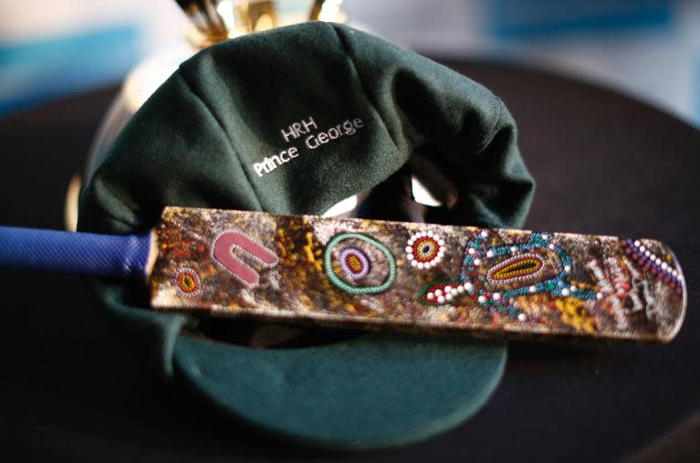 A 'baggy green' Australian cricketers cap bearing the name of Prince George is pictured with a miniature cricket bat before being presented during a reception at the Sydney Opera House on April 16, 2014