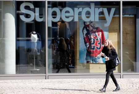 FILE PHOTO: A woman walks past a Superdry fashion store in Berlin, Germany, March 17, 2016. REUTERS/Fabrizio Bensch/File Photo