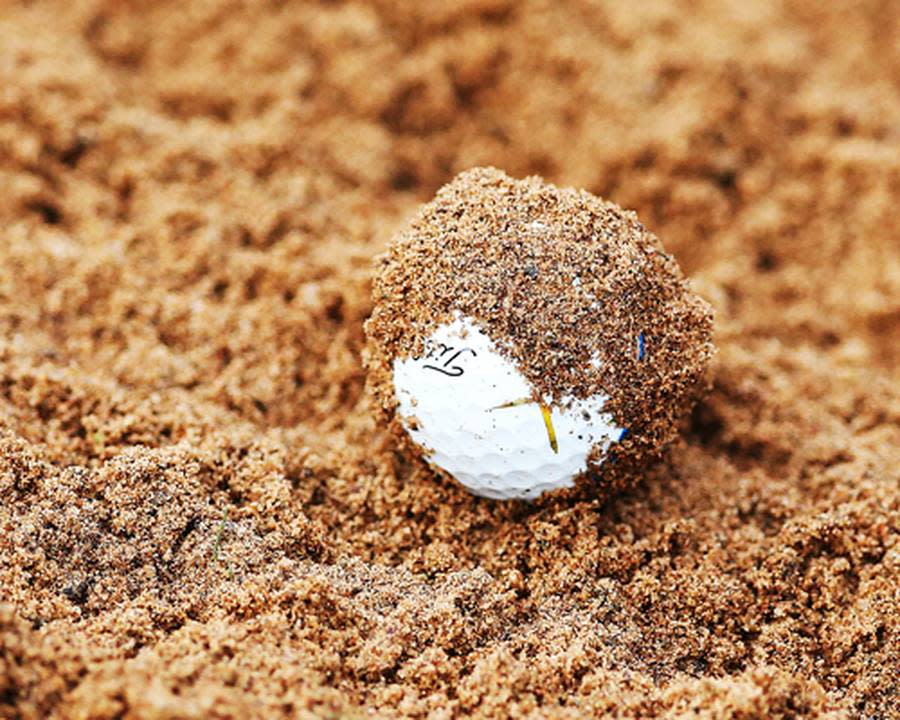 Na, wer versteckt sich denn da unter dem Sand? Glücklicherweise sind Golfbälle weiß und nicht braun..