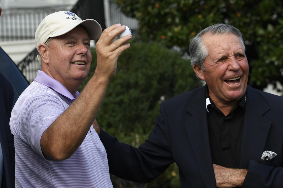 Sen. Lindsey Graham, R-S.C., left, holds up a golf ball as he shares a laugh with golfer Gary Player after they returned to the White House in Washington, Saturday, Sept. 28, 2019, after spending the day playing golf with President Donald Trump. (AP Photo/Susan Walsh)