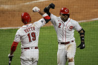 Cincinnati Reds' Joey Votto, left, celebrates the solo home run hit by Nick Castellanos, right, during the seventh inning of a baseball game against the Pittsburgh Pirates in Cincinnati, Monday, April 5, 2021. (AP Photo/Aaron Doster)