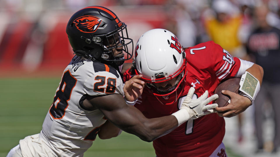 FILE - Oregon State defensive back Kitan Oladapo (28) tries to tackle Utah quarterback Cameron Rising before Rising scored in the first half of an NCAA college football game, Saturday, Oct. 1, 2022, in Salt Lake City. Oregon State opens their season at San Jose State on Sept. 3. (AP Photo/Rick Bowmer, File)