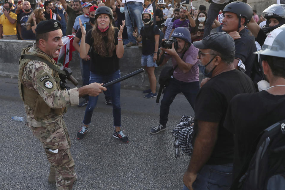 A Lebanese army soldier shouts as he tries to push back the anti-government protesters, during a protest against the Lebanese President Michel Aoun near the presidential palace, in Baabda east of Beirut, Lebanon, Saturday, Sept. 12, 2020. Soldiers fired rubber bullets and live rounds in the air to disperse hundreds of protesters trying to march to the presidential palace during an anti-government demonstration. (AP Photo/Bilal Hussein)