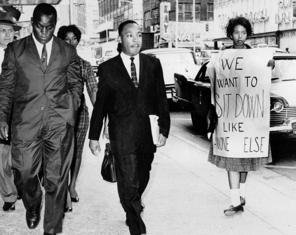 Dr. Martin Luther King Jr. under arrest by Atlanta Police Captain R.E. Little, left rear, passes through a picket line in front of a downtown department store on Oct. 9, 1960.  With King is another demonstration leader, Lonnie King and an unidentified woman. Dr. Martin Luther King Jr. was among the 48 African-Americans arrested following demonstrations at several department and variety stores protesting lunch counter segregation.