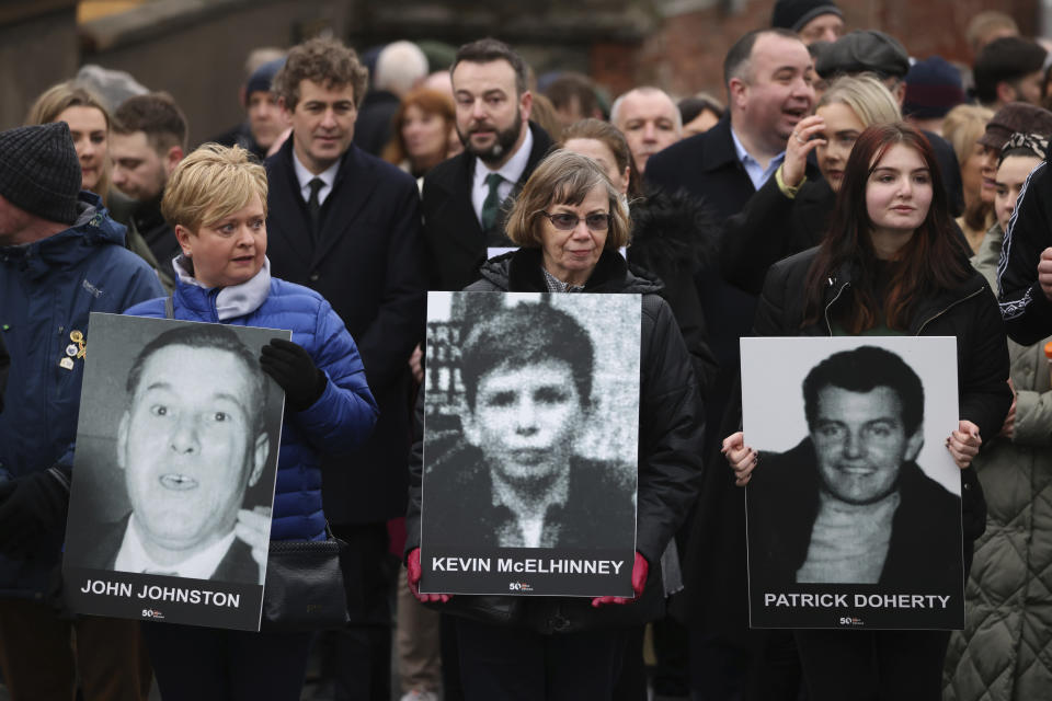 Relatives of those who were killed in the Bloody Sunday shootings with photographs bearing their names as they take part in a march to commemorate the 50th anniversary of the 'Bloody Sunday' in Londonderry, Sunday, Jan. 30, 2022. In 1972 British soldiers shot 28 unarmed civilians at a civil rights march, killing 13 on what is known as Bloody Sunday or the Bogside Massacre. Sunday marks the 50th anniversary of the shootings in the Bogside area of Londonderry .(AP Photo/Peter Morrison)