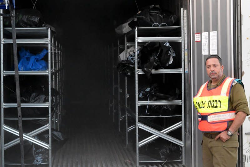 A soldier from the military rabbinate unit stands by containers full of bodies and body parts of people murdered by Hamas near the Gaza border, at the military morgue on the Shura Army Base near Ramla, on Tuesday. The process of identifying the dead is complicated by the extreme mutilation and severely burned bodies. Photo by Debbie Hill/UPI