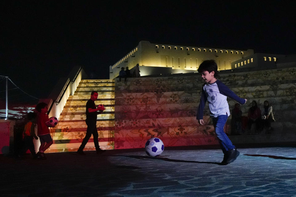 A child plays with a soccer ball at Katara Beach during the World Cup soccer tournament, in Doha, Qatar, Thursday, Nov. 24, 2022. (AP Photo/Julio Cortez)