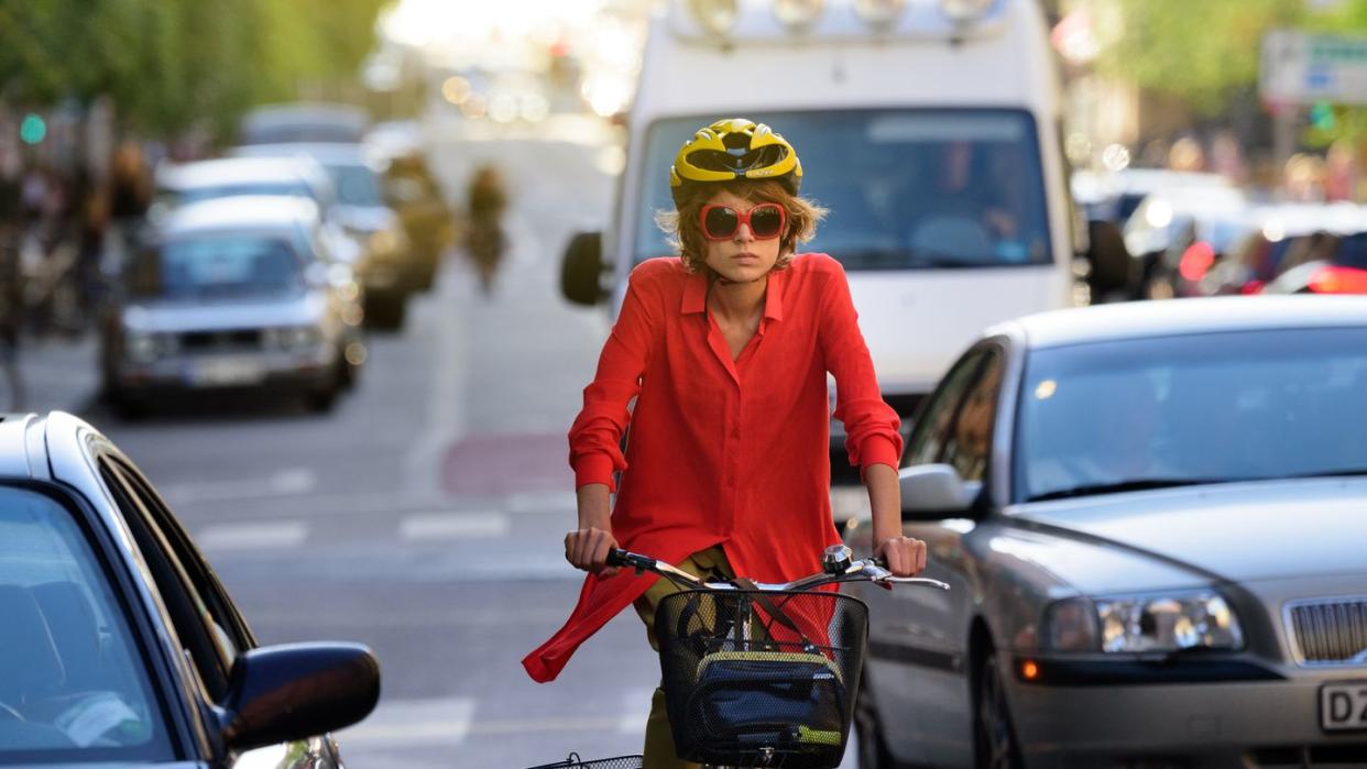 young woman on bike, in traffic, dooring, danger
