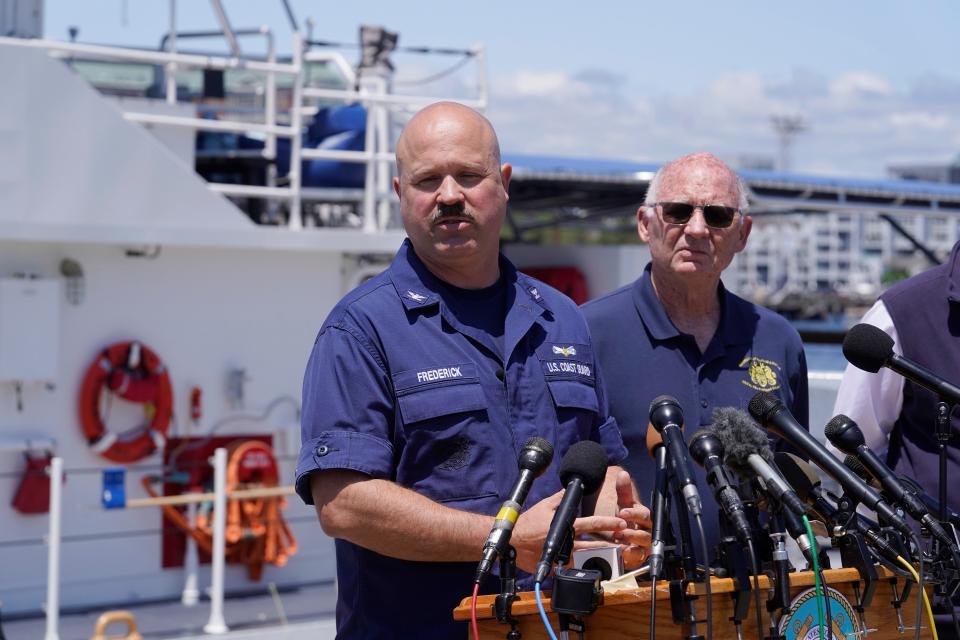 U.S. Coast Guard Capt. Jamie Frederick, left, faces reporters as Paul Hankins, U.S. Navy civilian contractor, supervisor of salvage, right, looks on during a news conference on Wednesday at Coast Guard Base Boston.