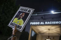 FILE - A protester holds up a photo of Brazilian soccer star Vinicius Jr and a message that reads in Portuguese; "Fight racism" during a protest against the racism suffered by Vinicius, who plays for Spain's Real Madrid, outside the Spanish Consulate in Sao Paulo, Brazil, Tuesday, May 23, 2023. Vinicius, who is Black, has been subjected to repeated racist taunts since he arrived in Spain five years ago. (AP Photo/Tuane Fernandes, File)