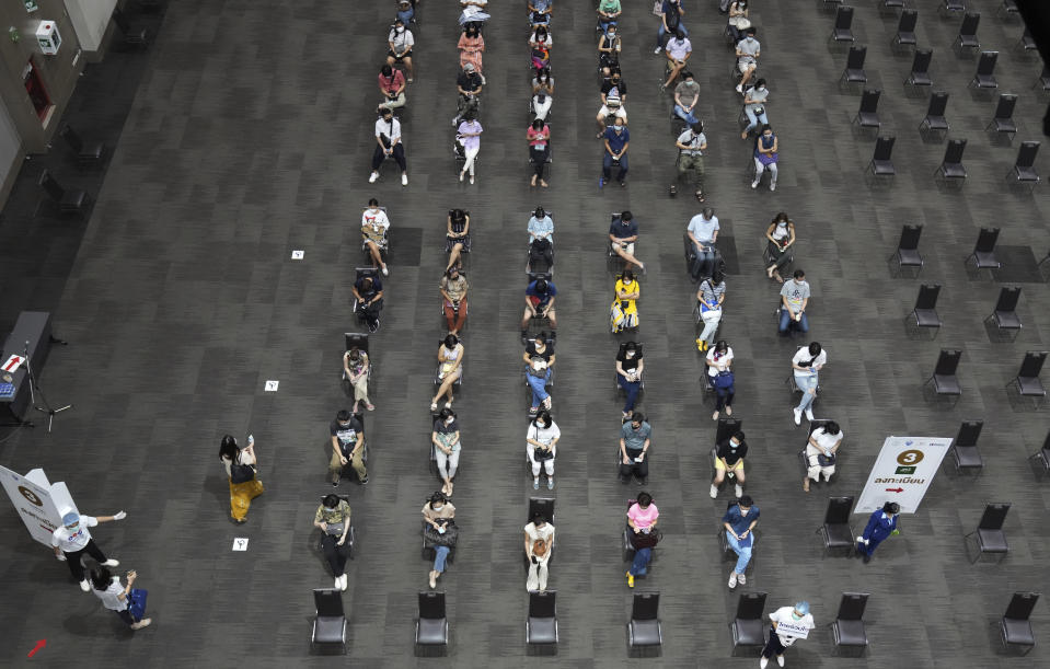 People wait for the the AstraZeneca COVID-19 vaccination at Paragon shopping mall in Bangkok, Thailand, Monday, June 7, 2021. Health authorities in Thailand on Monday began their much-anticipated mass rollout of locally produced AstraZeneca vaccine, but it appeared that supplies were falling short of demand from patients who had scheduled vaccinations for this week. (AP Photo/Sakchai Lalit)