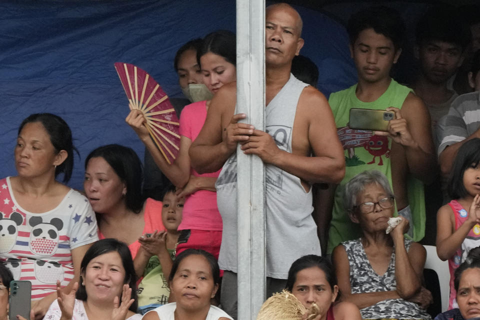 Evacuees watch to catch a glimpse of Philippine President Ferdinand Marcos Jr. as he visits an evacuation center in Guinobatan town, Albay province, northeastern Philippines, Wednesday, June 14, 2023. A gentle eruption of the Philippines' most active volcano that has forced nearly 18,000 people to flee to emergency shelters could last for months and create a protracted crisis, officials said Wednesday. (AP Photo/Aaron Favila)