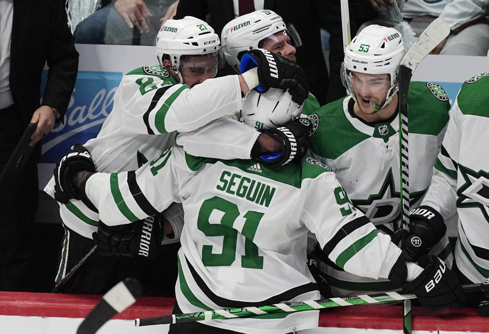 Dallas Stars center Tyler Seguin, front, is congratulated after scoring an empty-net goal against the Colorado Avalanche during the third period of Game 3 of an NHL hockey Stanley Cup playoff series Saturday, May 11, 2024, in Denver. (AP Photo/David Zalubowski)