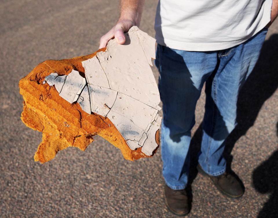 An onlooker takes a piece of history home from the demolished Casa Grande Domes on Jan. 11, 2023.